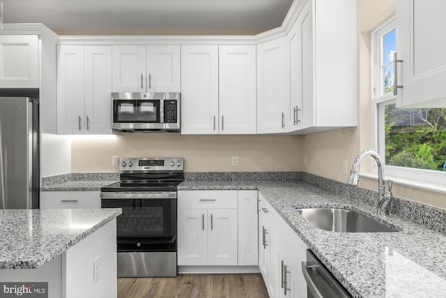 kitchen featuring a wealth of natural light, sink, and white cabinetry