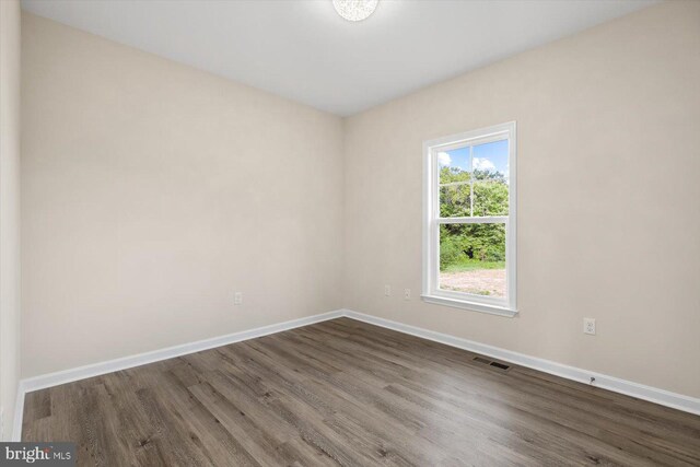 full bathroom featuring hardwood / wood-style flooring, vanity, tiled shower / bath combo, and toilet