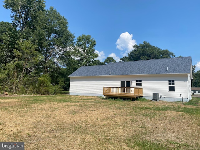 rear view of property with a deck, a lawn, and cooling unit