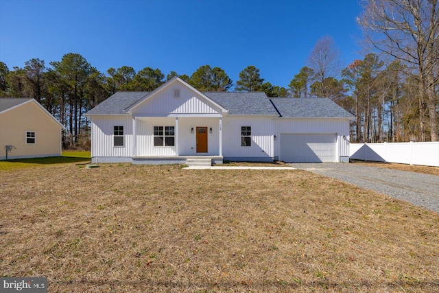 modern inspired farmhouse featuring covered porch, a garage, fence, driveway, and a front lawn