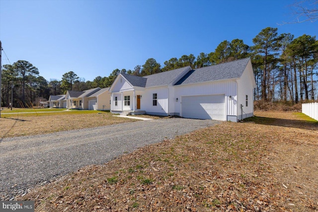 view of front of house with an attached garage and gravel driveway