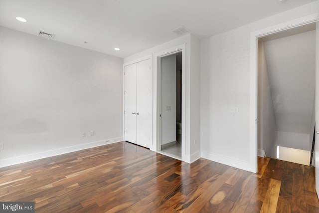 unfurnished bedroom with dark hardwood / wood-style flooring