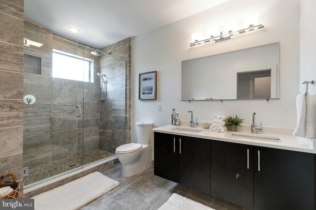 bathroom featuring toilet, a shower with shower door, and vanity