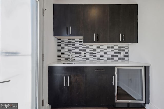 kitchen with wine cooler, decorative backsplash, and dark brown cabinetry