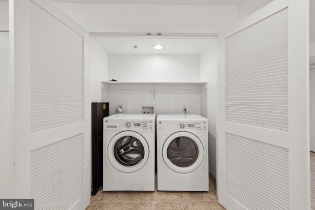 laundry area featuring light tile patterned flooring and washer and clothes dryer