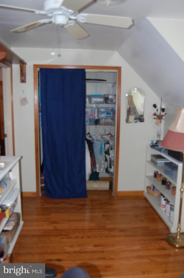 bedroom featuring ceiling fan, wood-type flooring, and lofted ceiling