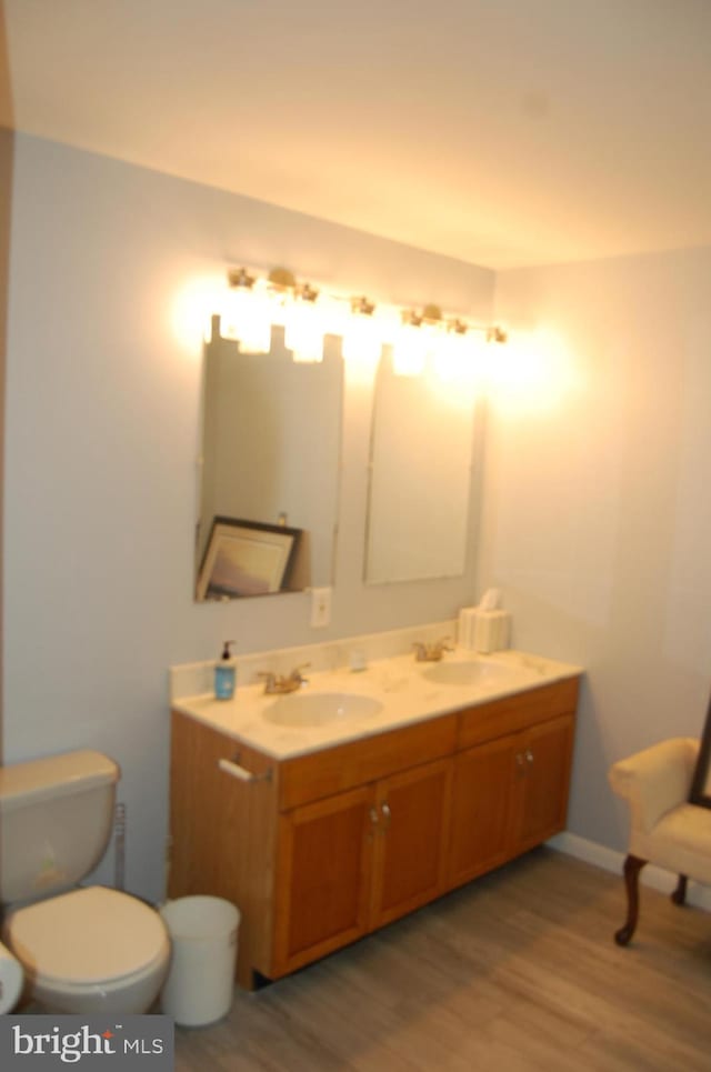 bathroom featuring vanity, toilet, and hardwood / wood-style floors