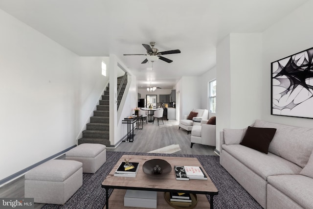 living room featuring hardwood / wood-style flooring and ceiling fan with notable chandelier