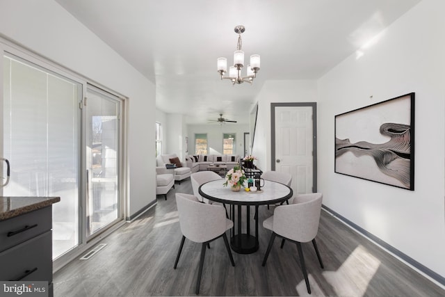 dining room with hardwood / wood-style flooring and ceiling fan with notable chandelier