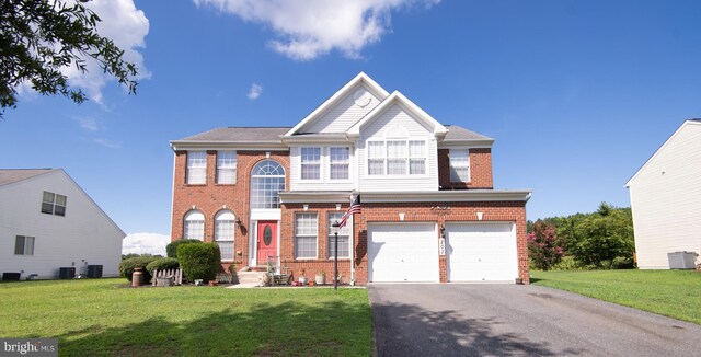 view of front facade with central AC unit, a garage, and a front lawn