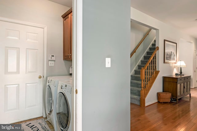 laundry area with cabinets, hardwood / wood-style floors, and separate washer and dryer