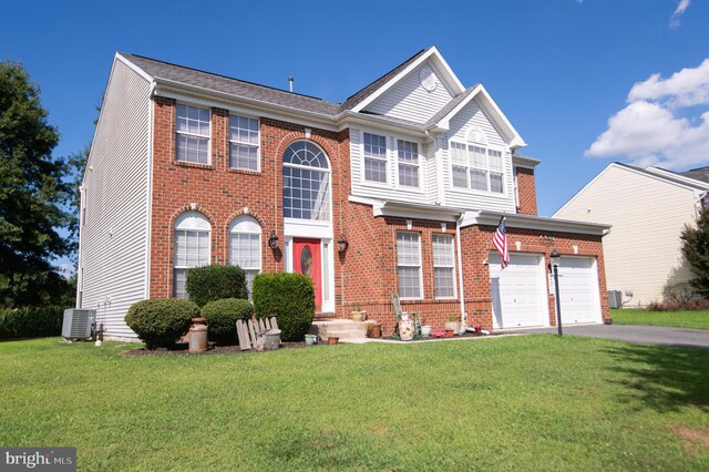 view of front of property with a garage, central AC unit, and a front lawn