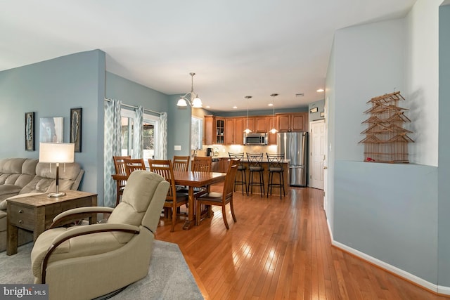 living room with an inviting chandelier and light wood-type flooring