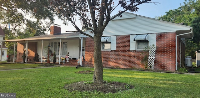 bungalow with covered porch and a front yard