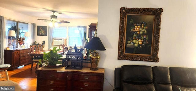 sitting room with ceiling fan, cooling unit, and wood-type flooring