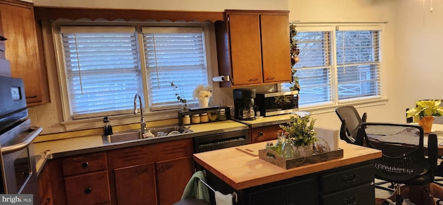 kitchen featuring brown cabinetry, light countertops, and a sink