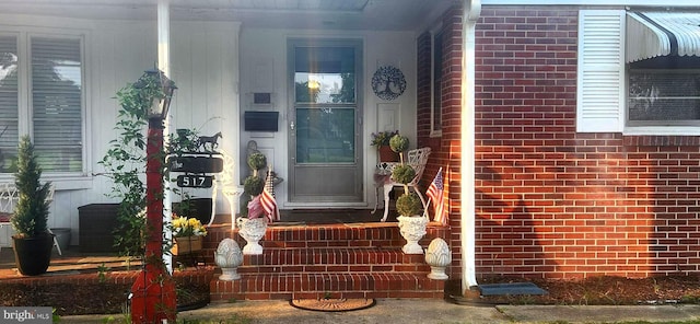 doorway to property featuring brick siding