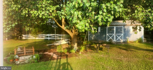 view of yard with a storage unit, an outdoor structure, and fence