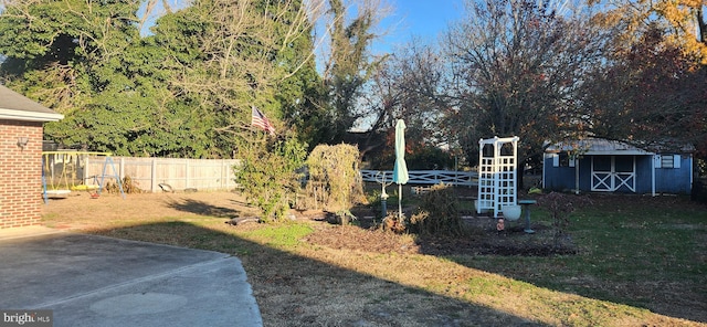 view of yard with a shed, an outdoor structure, and fence