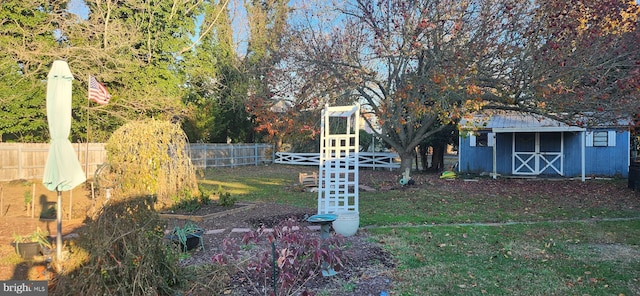 view of yard with a fenced backyard, a storage unit, and an outdoor structure