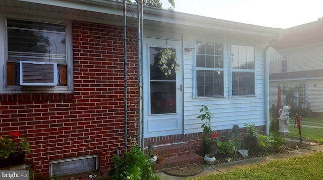 doorway to property with cooling unit and brick siding