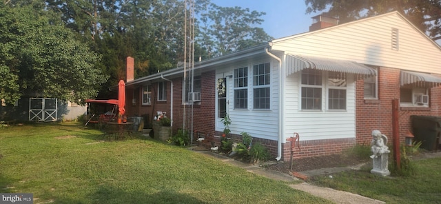 view of side of property featuring cooling unit, a yard, and a chimney