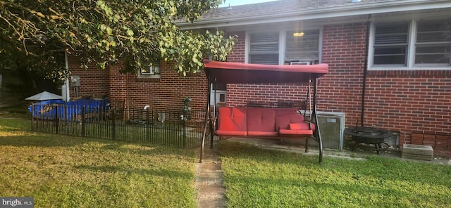 rear view of house with brick siding, fence, and a yard