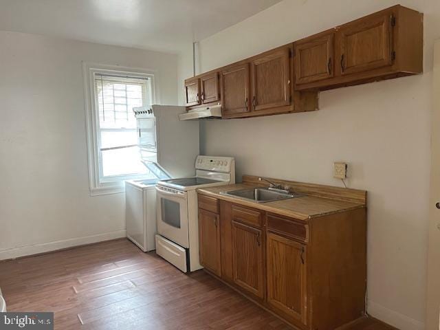 kitchen featuring hardwood / wood-style flooring, sink, electric range, and washer / dryer