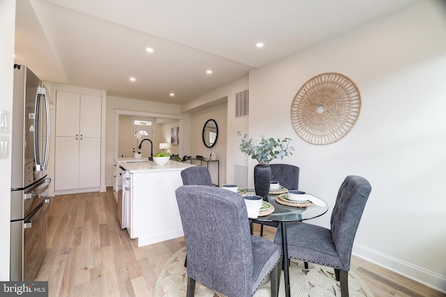 dining space featuring sink and light hardwood / wood-style flooring