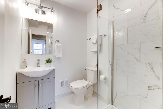 bathroom featuring vanity, toilet, and a tile shower