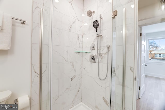 bathroom with toilet, hardwood / wood-style floors, and an enclosed shower