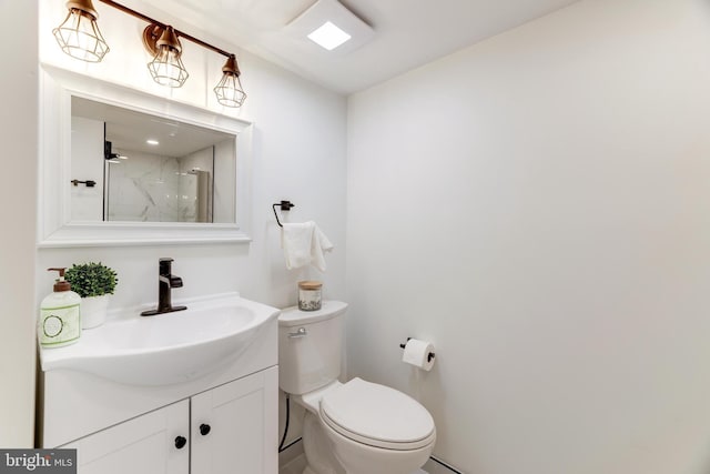 bathroom featuring vanity, toilet, and walk in shower