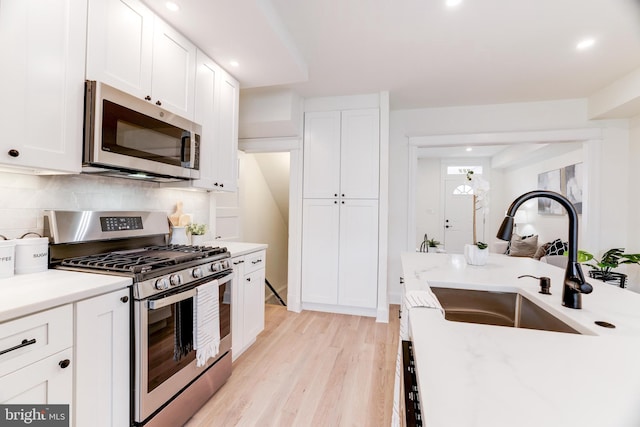 kitchen featuring white cabinets, light hardwood / wood-style flooring, stainless steel appliances, and sink