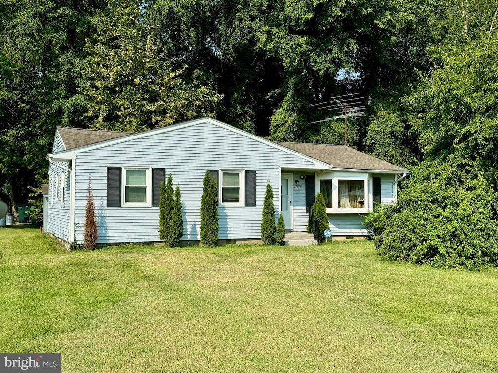 ranch-style house featuring entry steps, roof with shingles, a front lawn, and crawl space