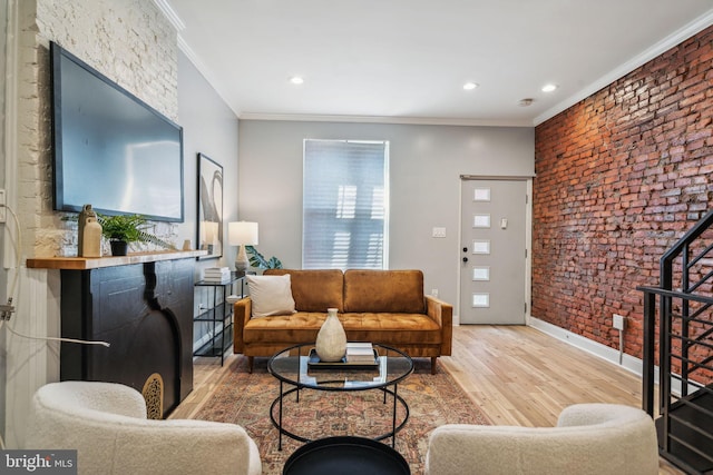 living room with brick wall, crown molding, and hardwood / wood-style flooring