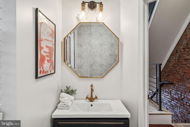 bathroom with vanity, wood-type flooring, and brick wall