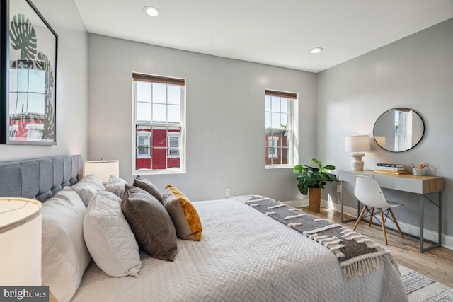 bedroom with light wood-type flooring and multiple windows