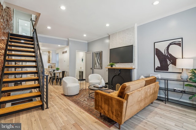 living room with ornamental molding and light hardwood / wood-style floors