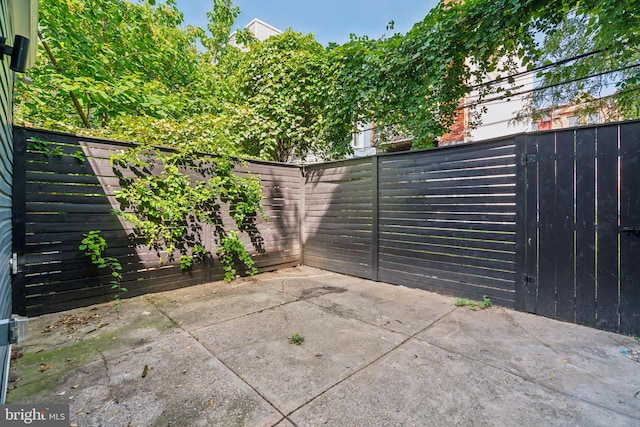 view of gate featuring a patio area