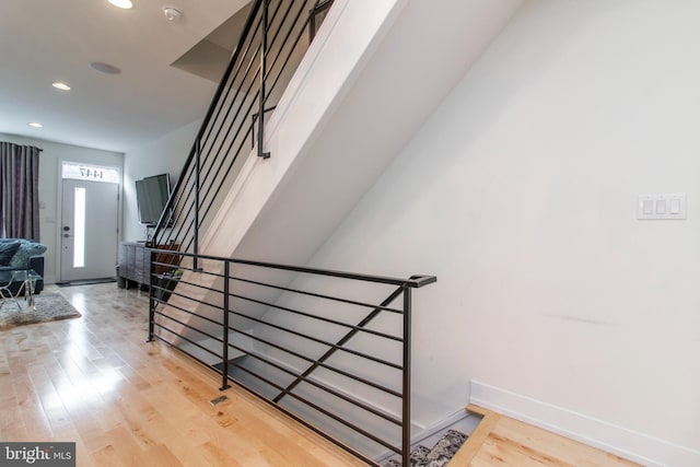 stairs featuring hardwood / wood-style floors