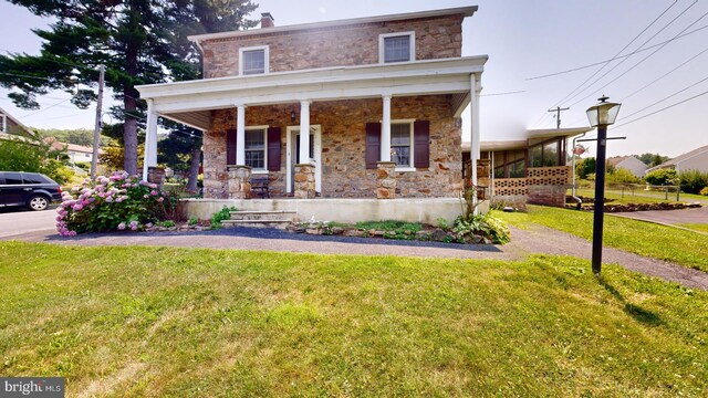 view of front of property featuring covered porch and a front yard