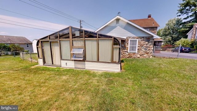 rear view of house featuring a yard and an outbuilding