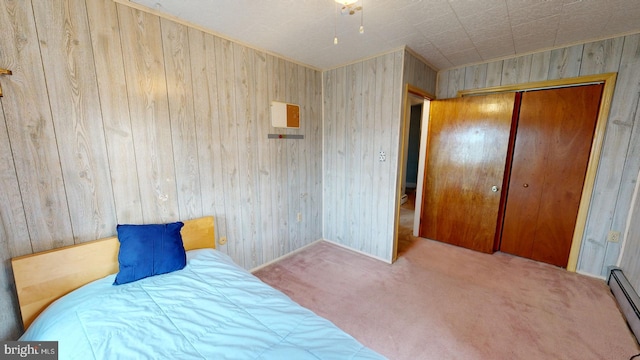 carpeted bedroom with a closet, wooden walls, and baseboard heating