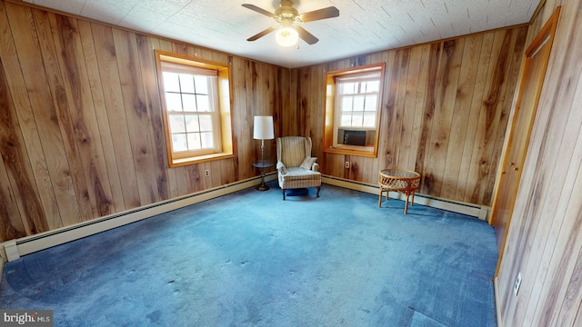 unfurnished room featuring a baseboard radiator, carpet, and wooden walls