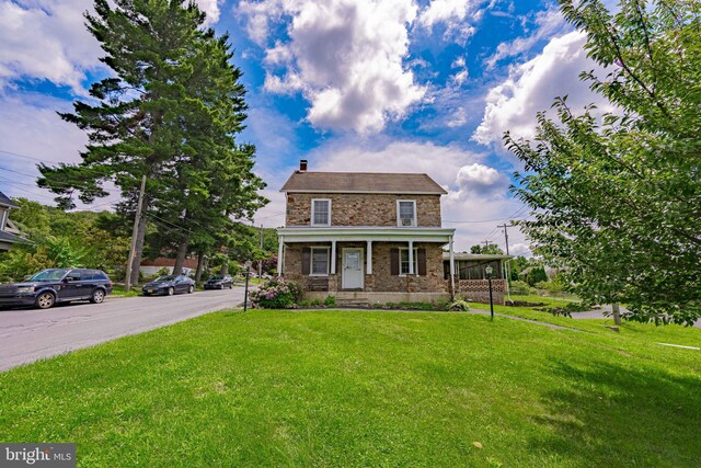 view of front facade featuring covered porch and a front yard