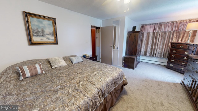 bedroom featuring ceiling fan, baseboard heating, and light colored carpet