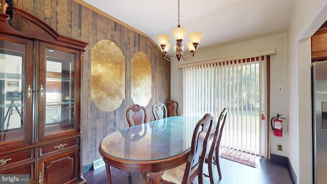 dining room with hardwood / wood-style floors and an inviting chandelier