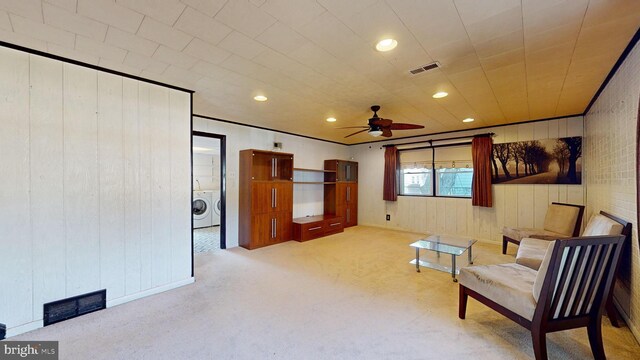 living area featuring ceiling fan, light carpet, and washer / clothes dryer