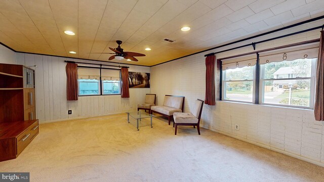 living area featuring light colored carpet and ceiling fan