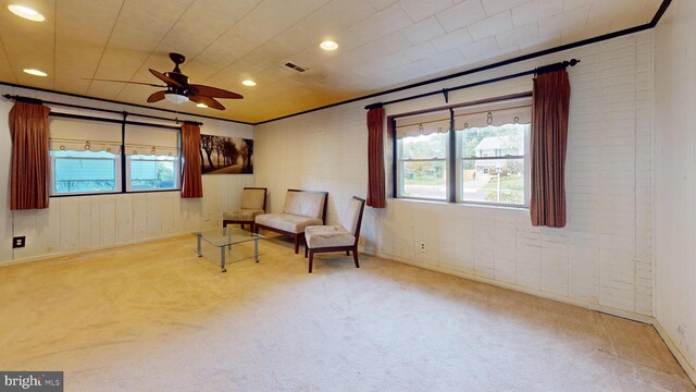 living area featuring light colored carpet and ceiling fan